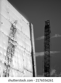 Construction Shadow, Tall Crane Reflected On Side Of Building Wrapped In White Protective Plastic Shrink Wrap In Tauranga.