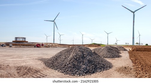 Construction Site And Agriculture Field. Preparation Of A Wind Turbines With Concrete And Steel. Building Wind Turbines. Wind Turbine Base And Pile Of Sand And Gravel For Construction. 