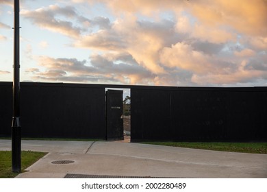 Construction Site With Black Panel Hoarding With Open Door Access.