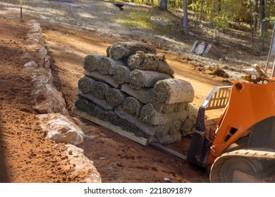 Construction Site Boom Lift Is Used Unload Turf Rolls From Pallets For Landscaping In Order To Lay Green Grass Turf.