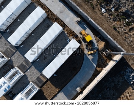 Construction site of containerized energy storage power station with heavy machinery and modular units