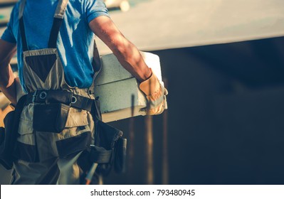 Construction Site Contractor Moving Heavy Building Materials in His Hands. Residential Development Industry. - Shutterstock ID 793480945