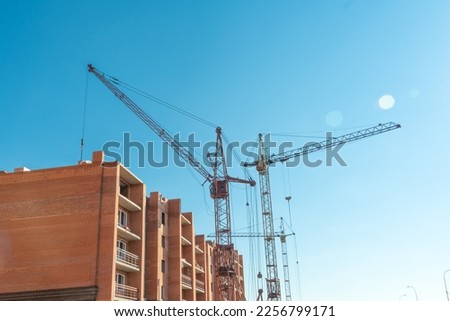 Construction site with a crane.Long-term construction.A new building under construction,bottom-up view.Unfinished skyscraper,frozen construction.Unfinished construction of a multi-storey residential