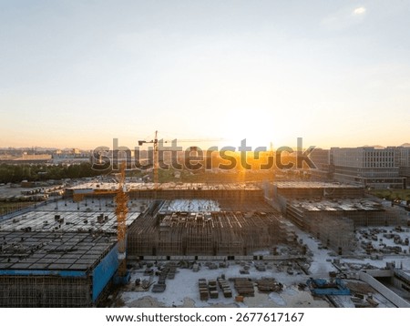 Construction site with cranes at sunset