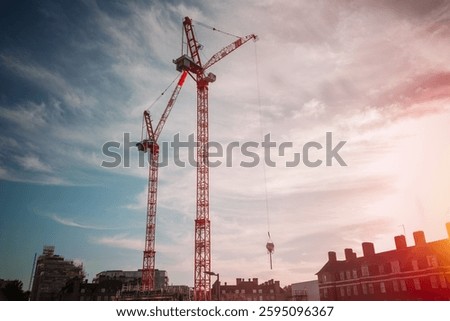 Construction site cranes in warm sunset light in London, UK