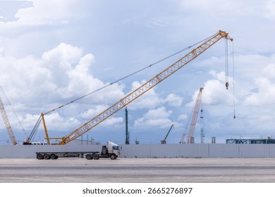 Construction site with construction crawler cranes and multi storey unfinished buildings, Many high rise cranes and industrial construction equipment, Contruction site blue sky background.