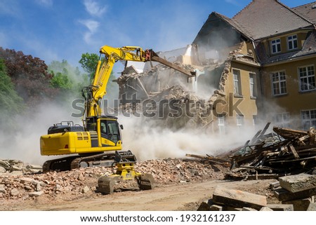 Construction site digger yellow demolishing house for reconstruction