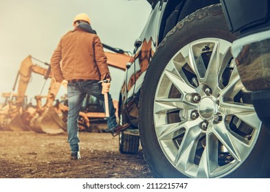 Construction Site Equipment And The Business Owner Next To His Truck. Heavy Duty Excavators And Bulldozers Rental Company.