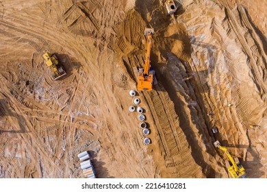 At Construction Site, An Excavator Digs Trench In Order To Lay Sewer Lines And Connect Underground Storm Sewer Pipes