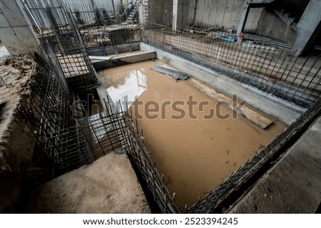 A construction site featuring a large puddle of standing water