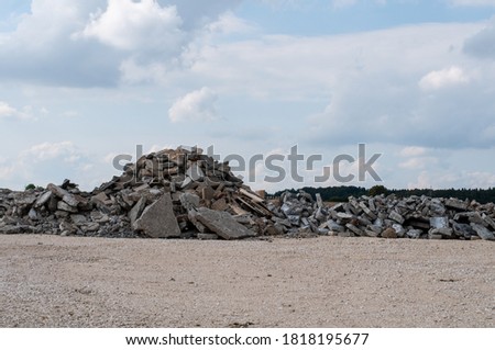 a construction site with gravel floor and a pile of broken rubble