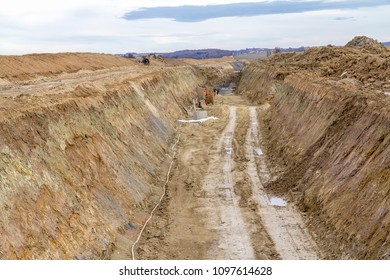 Construction Site Including A Big Trench With Lots Of Earth And Loam