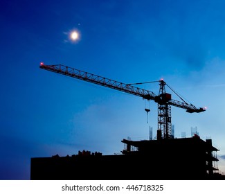 Construction Site. Industrial construction cranes and building silhouettes on night sky. Beautiful colorful night landscape. - Powered by Shutterstock