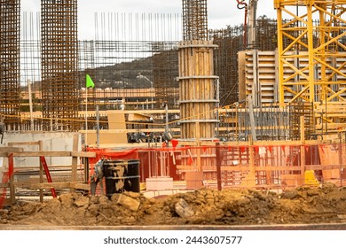 A construction site with iron and wood colums in the background 