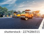 Construction site is laying new asphalt pavement, road construction workers and road construction machinery scene. Highway construction site scene.