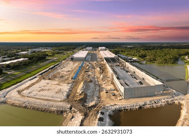 Construction site of logistic center with assembling of concrete and metal frame walls. Aerial view of large development area of commercial structure