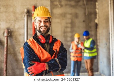 Construction site manager standing  wearing safety vest and helmet, thinking at construction site. Young architect watching construction site with confidence. - Powered by Shutterstock