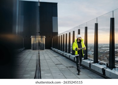 Construction site manager using digital tablet to inspect building progress.
