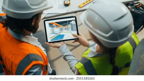Construction and Site Managers Having a Meeting at a Construction Site. Specialists Using Tablet Computer to Demonstrate the Visualization of a 3D Virtual Building Plan from Inside