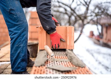 Construction Site And Mason Bricklayer Working With Bricks, Cement And Mortar For Building New House