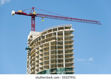 Construction Site - Modern Semicircle Shaped Building And The Red Crane.