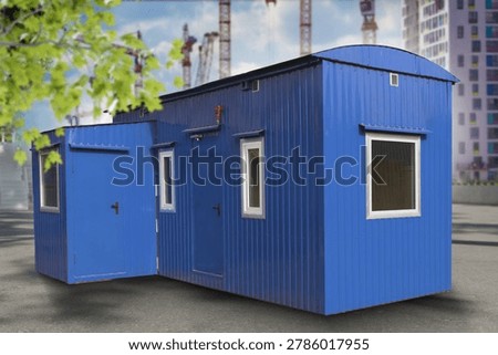 Construction site office, modular building. Portable container cabin installed near cranes, used for site management, staff workspace and temporary facilities.