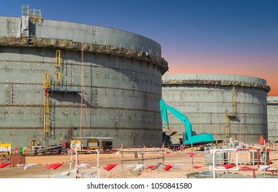 Construction site oil   gas industrial  Huge oil storage tank  Heavy construction machine doing building  and the workers 
