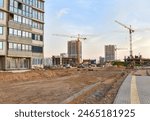 Construction site. Paving bricks installing on pedestrian. Laying paving slabs and borders. Screeding sand for install concrete blocks. Road work. Buildings under construction. Tower crane on Housing 