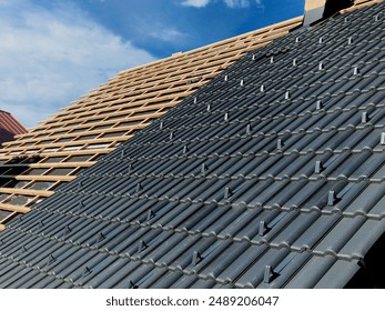 construction site with several roofs in progress. Roofs with vapor-permeable foil. roof tiles are placed on the roof. concrete chimney passes through. approval quality control. view from above