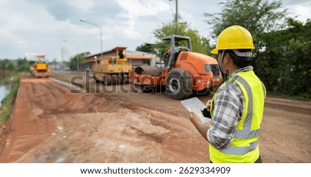 A construction site supervisor documenting progress using a digital tablet, showcasing modern project management in an active building site environment.