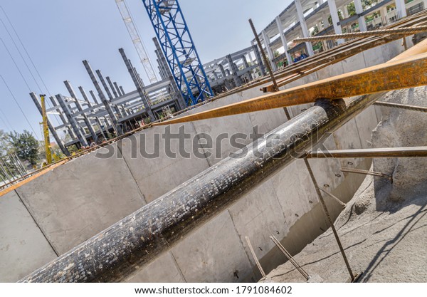 Construction site\
with surrounding wall or tilt-up panels and girders\
Deep\
foundations made of huge cement\
slabs