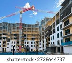 Construction site with tower cranes moving while building residential apartment blocks