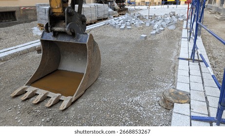 Construction site undergoing paving work with heavy machinery at a busy urban location in France