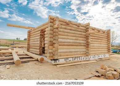 Construction site of wooden mountain house. Traditional log cabin built from wood logs on sunny summer day. Cottage house design
