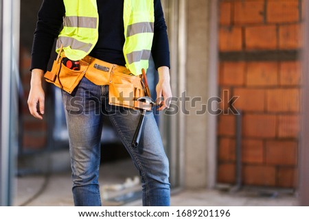 construction site worker wearing velt with tools