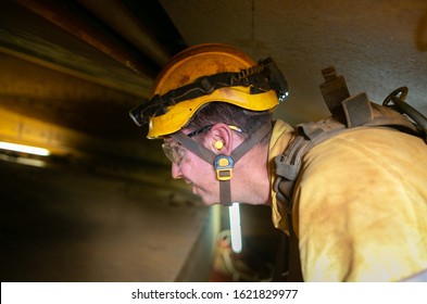 Construction Site Worker Wearing Yellow  Safety Hard Hat Fall Protection Clear Glass Ear Plug While Working In Confined Space Noisy Areas 