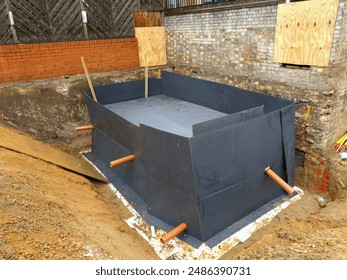 Construction site with workers installing an attenuation tank protected by Cordek beam form and Terram geotextile. Foundation preparation and drainage system installation.
