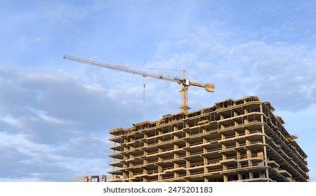 Construction of a skyscraper. Tower Crane on formworks on construction site. Construction crane on Housing. Construction of the Multi Storey Residential Building.