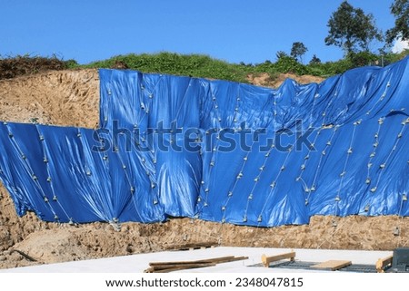 Construction slope area covered in blue tarp, to prevent erosion