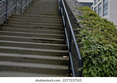 construction of a steep staircase by the stone wall car park with high durability even under heavy load galvanized steel floor grate and railings. gabion above him a wire fence.  - Shutterstock ID 2277237555