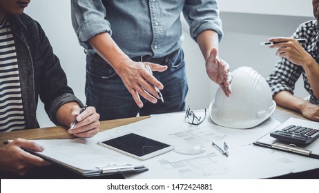 Bau- und Strukturkonzept des Ingenieurs oder Architektentreffens für die Projektarbeit mit Partner- und Ingenieurwerkzeugen auf Modellbau und Bauplan auf dem Baugelände, Vertrag für beide Unternehmen.