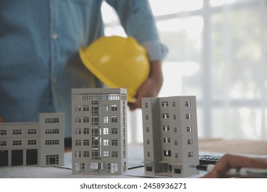 Construction and structure concept of Engineer or architect meeting for project working with partner and engineering tools on model building and blueprint in working site, contract for both companies.