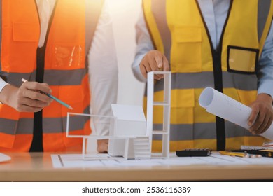 Construction and structure concept of Engineer or architect meeting for project working with partner and engineering tools on model building and blueprint in working site, contract for both companies.