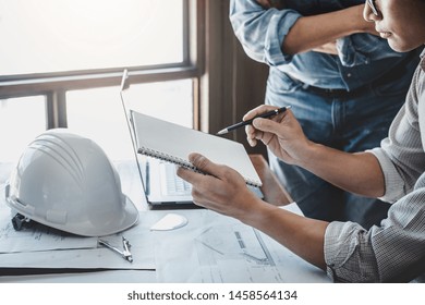 Construction and structure concept of engineer working drawing on blueprint meeting for project working with partner on model building and engineering tools in working site, construction concept.