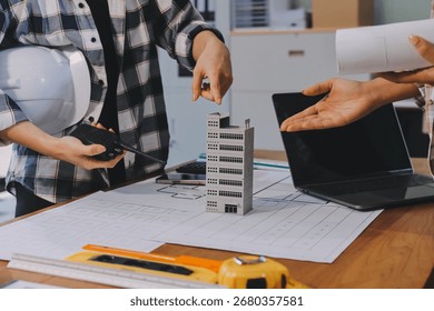 Construction and structure concept of engineer working drawing on blueprint meeting for project working with partner on model building and engineering tools in working site, construction concept. - Powered by Shutterstock - Get 15% off with code: PIKWIZARD15