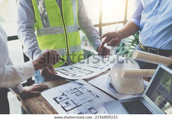 Construction and structure concept of engineer\
working drawing on blueprint meeting for project working with\
partner on model building and engineering tools in working site,\
construction\
concept
