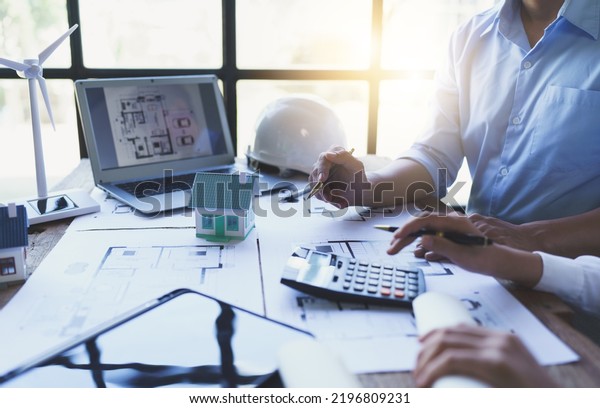 Construction and structure concept of engineer\
working drawing on blueprint meeting for project working with\
partner on model building and engineering tools in working site,\
construction\
concept