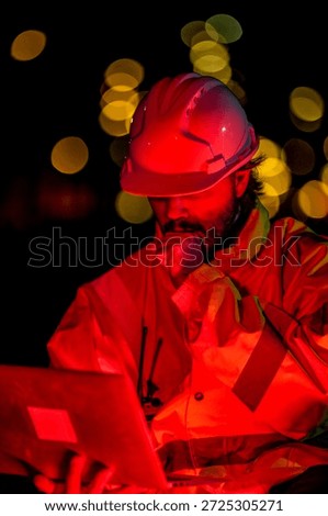 Construction supervisor giving instructions via walkie talkie at site. Night shift engineer using laptop to control building project logistics