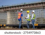 Construction supervisors reviewing project progress at infrastructure site, Engineering team inspecting bridge construction, Worker team planning construction work at large infrastructure projects