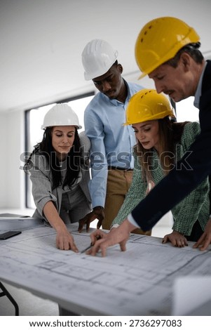 Construction team collaborating on building plans, discussing architectural project details and engineering designs at a construction site